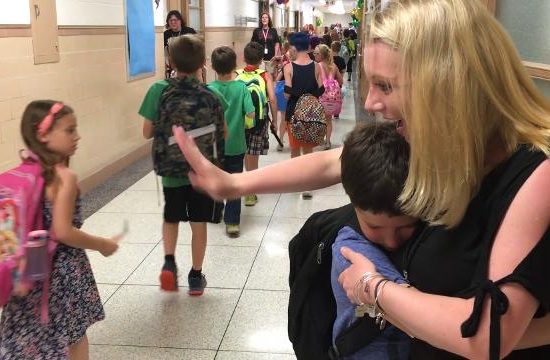 Teacher hugs students